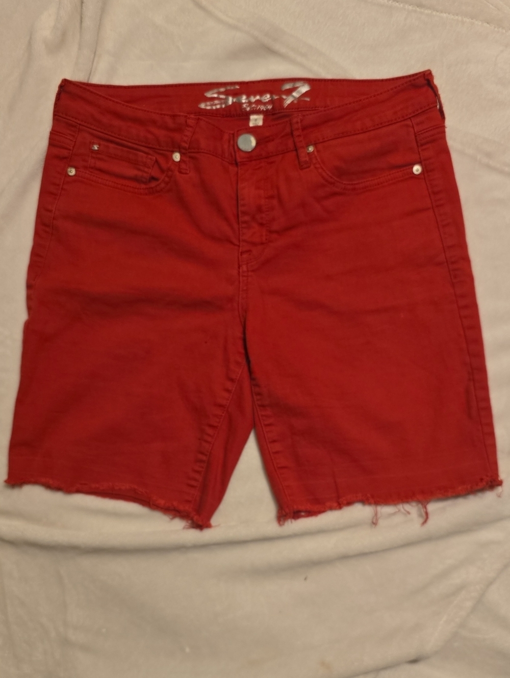Seven7 8 Sunset Bermuda shorts in holly berry red color, featuring a raw, frayed